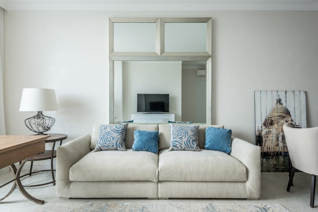 Stylish modern living room with beige sofa, blue cushions, and decorative elements.